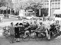 Vintage black and white photo of servicemen, women, and midway performers enjoying the Bicycle Ride at Steeplechase Park in 1942