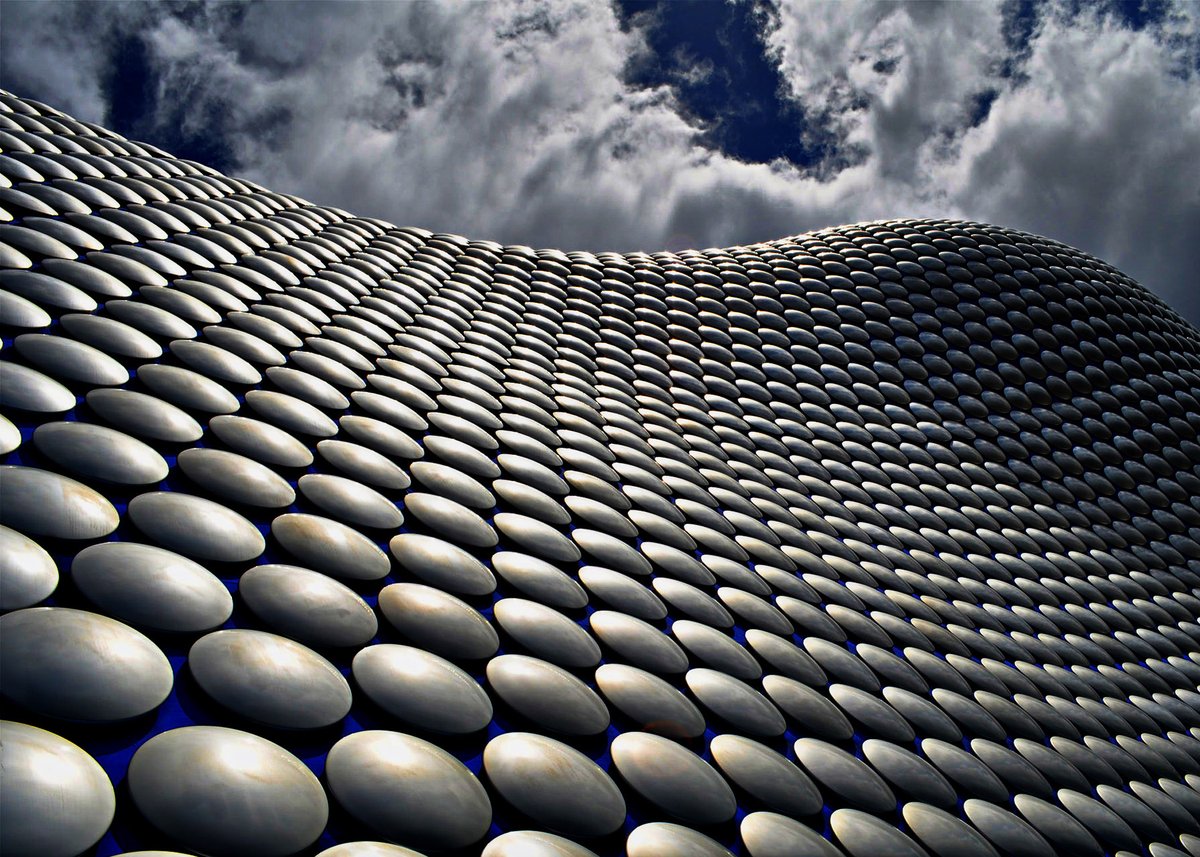 Skyline of Birmingham city in the United Kingdom with modern buildings under a partly cloudy sky