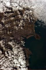 Aerial view of Dublin city and its port from the International Space Station, showcasing the River Liffey mouth and surrounding areas including Malahide and Bray.
