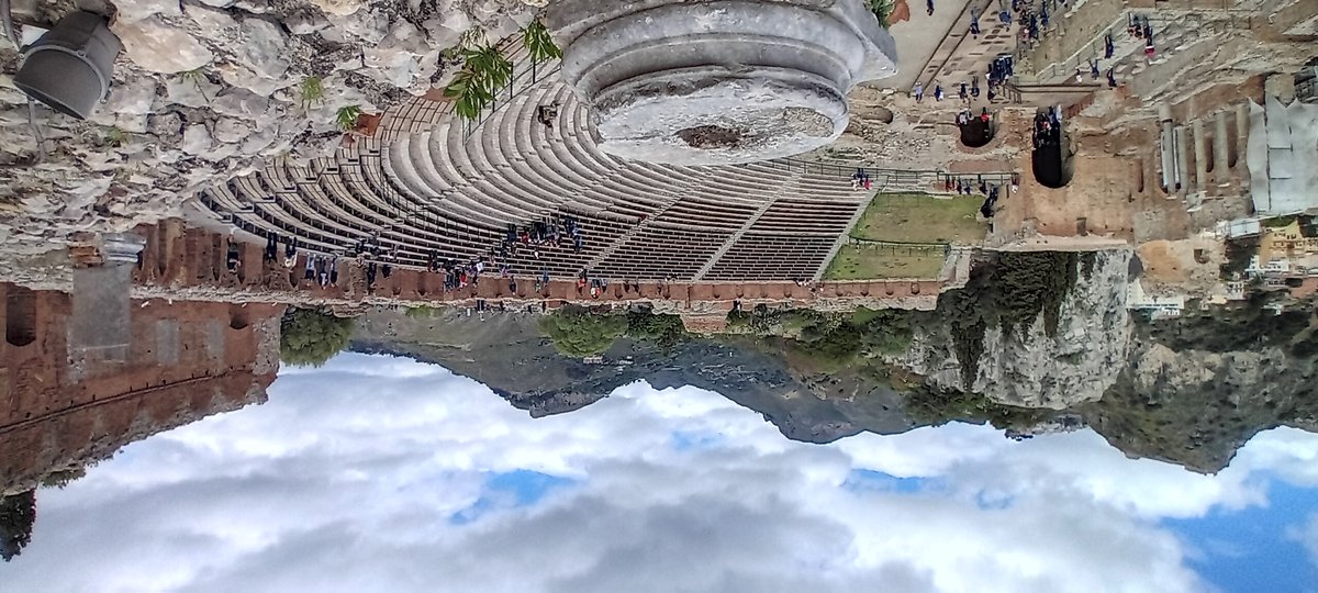 Ancient Anfiteatro di Taormina amphitheater with Mount Etna in the background