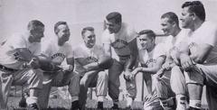 1956 Northwestern Wildcats football team coaching staff featuring Bo Schembechler, Paul Shoults, Dale Samuels, Ara Parseghian, Doc Urich, Bruce Betty, and Alex Agase