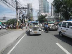 Cityscape of Ortigas Center in Mandaluyong City along Shaw Boulevard and San Miguel Avenue with modern high-rise buildings and traffic