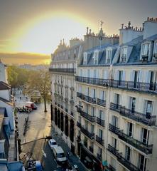Sunrise over the historic Marais district in Paris with warm orange and pink sky
