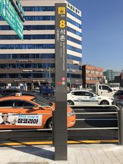 Seokchon Station Exit 8 pole sign with directional information in Seoul