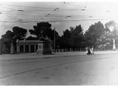 Women and children crossing a road near Boer War Memorial and Government House Gates on North Terrace