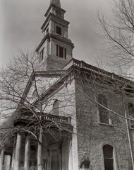 View looking up at porch and steeple of St. Mark's Church Manhattan with trees in foreground