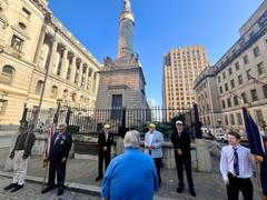 Ceremony held at the historic Battle Monument with participants gathered around