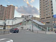 Hanaten Station exterior entrance with clear signage and people walking