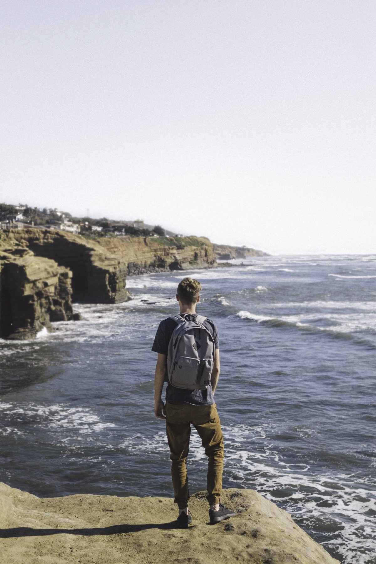 Sunset Cliffs in San Diego at sunset with ocean waves crashing against rocky shoreline