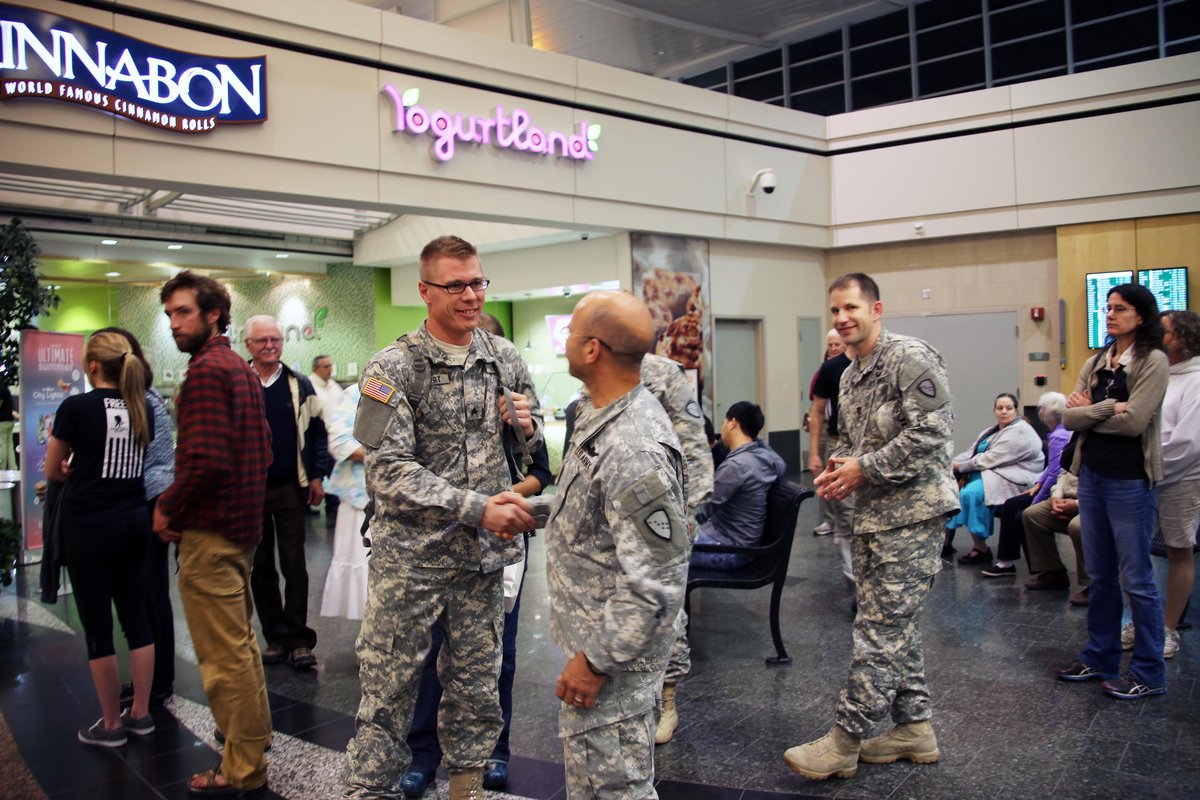 Alaska Army National Guardsman Sgt. Edward Wingert shaking hands with Command Sgt. Major Marc Petersen at Ted Stevens International Airport