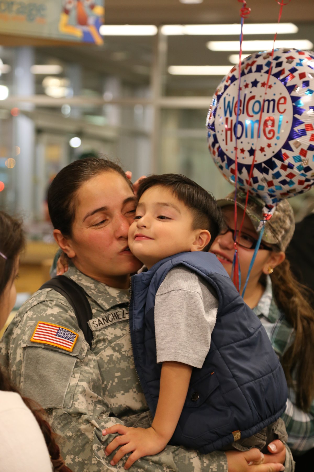 Alaska Army National Guardsman Sgt. Brenda Sanchez-Veliz kissing her son at airport after deployment