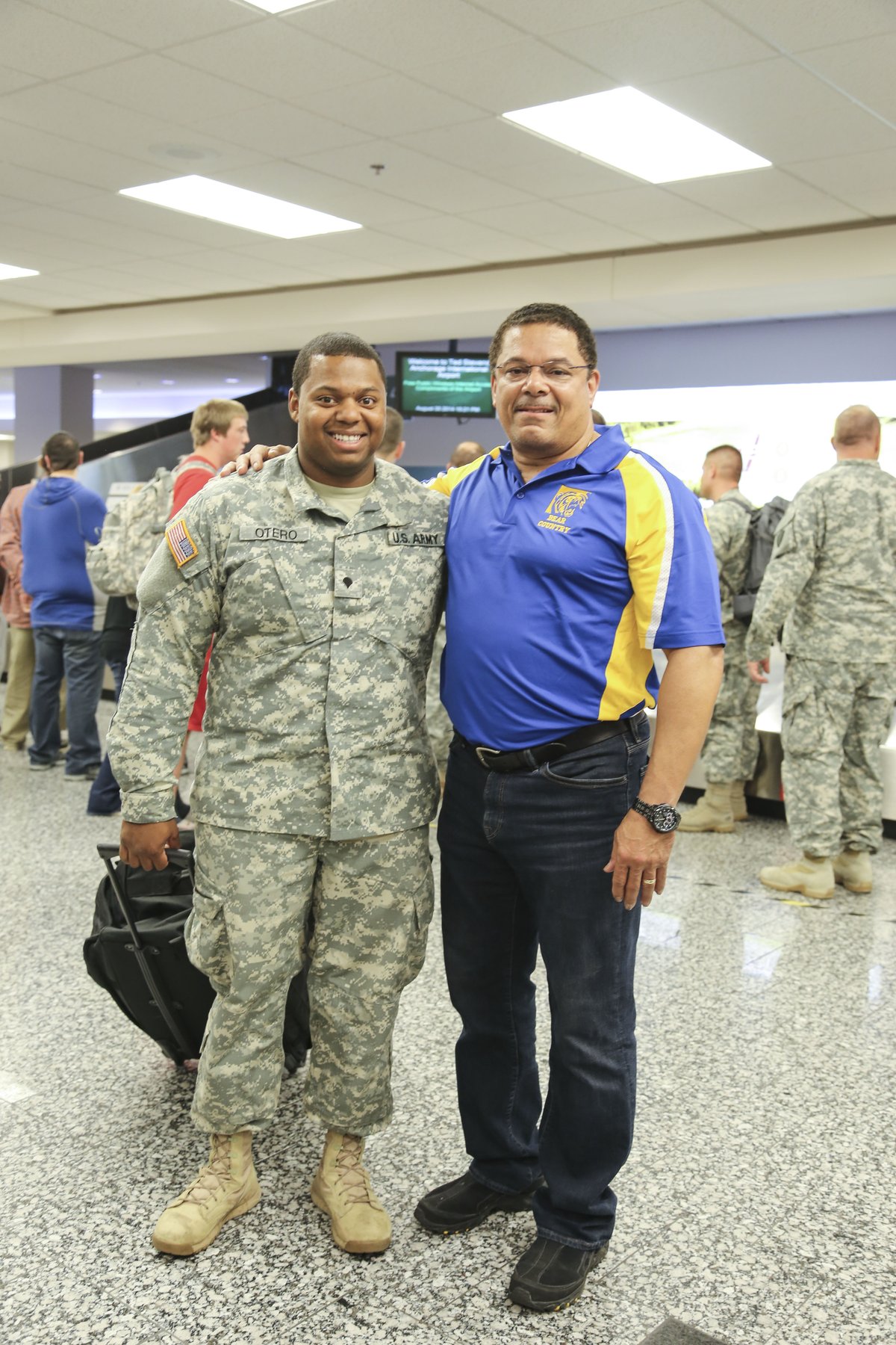 Alaska Army National Guardsman Spc. Bernardo Otero taking a photo with his father at Ted Stevens International Airport after deployment