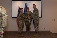 U.S. Air Force Lt. Col. Nicholas Lee receives 21st Logistics Readiness Squadron guidon from Col. David J. Wilson during a command ceremony at Peterson Air Force Base