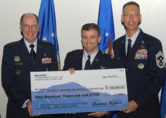 General C. Robert Kehler and Chief Master Sergeant Richard T. Small presenting $100,000 check to Lt. Col. Michael Sowa at AFSPC Heritage dinner