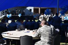 Airmen celebrating the Air Force's 71st birthday at Peterson Air Force Base with outdoor activities, food, live band, and cake