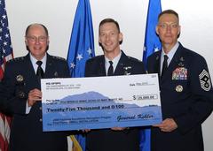 General C. Robert Kehler and Command Chief Master Sgt. Richard T. Small presenting a $25,000 check to Lt. Col. William Klug at Peterson Air Force Base