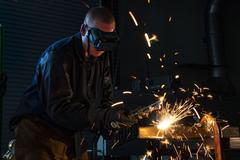 U.S. Air Force Senior Master Sgt. Justin Cruz cutting metal beam with oxy-acetylene cutter at Peterson Space Force Base