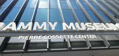 Exterior view of the Grammy Museum building with trees and bright evening sky in July 2022