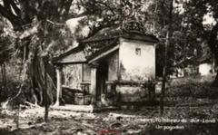 Small pavilion with a covered portico and phoenix-relief walls beside a large banyan tree at the Tomb of Gia Long near Hue, Vietnam, 1930