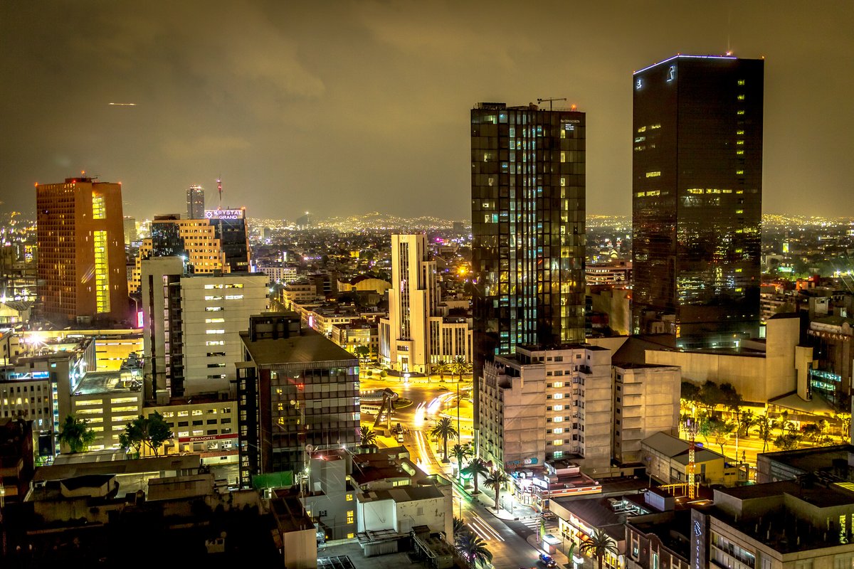 Panoramic view of Mexico City skyline at night with illuminated buildings and streets