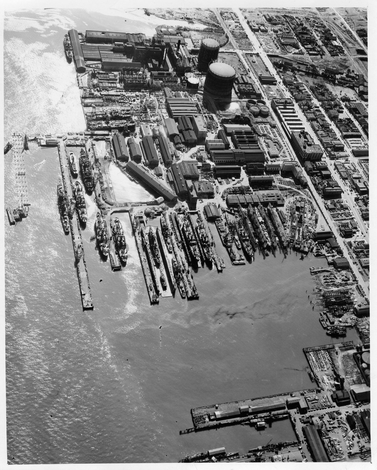 Aerial view of Bethlehem Union Iron Works shipyard in 1945 showing numerous buildings, docks, and ships under construction or repair