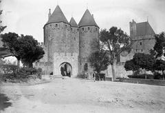 Ancient portal, towers, and city wall of Carcassonne with a cart and a man