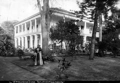 Queen Lili'uokalani standing under a Tamarind tree near Washington Place in 1893