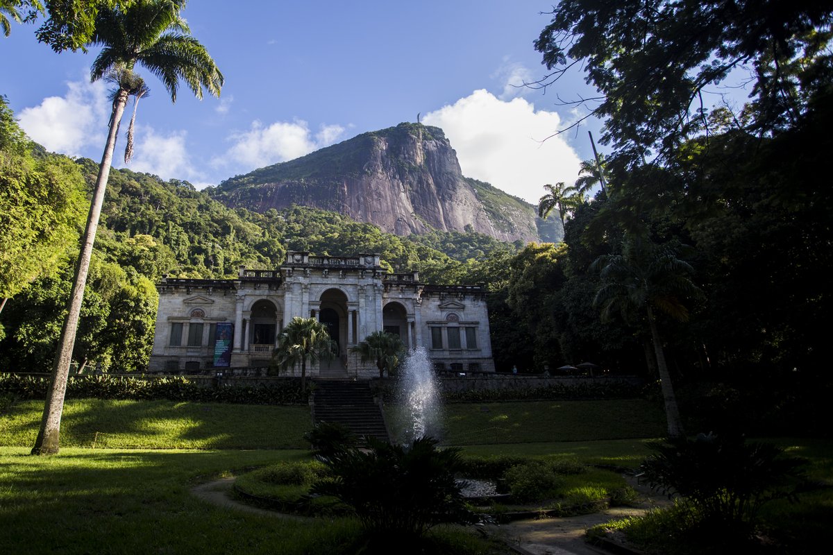 Beautiful historic building in Parque Lage surrounded by lush greenery and trees in Rio de Janeiro