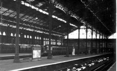 Interior view of Broad Street Station with most of the roof intact, showing high level concourse with shops and historic North London Railway steam locomotive model