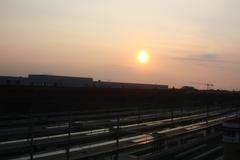 Sunset at Bruges train station with vivid orange sky and silhouetted buildings