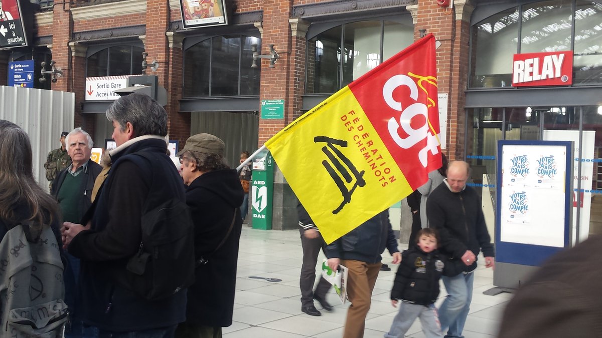 Man holding CGT Federation of Railway Workers flag at Lille-Flandres train station in April 2015