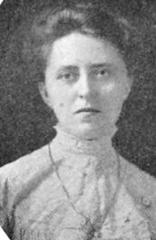 Portrait of a white woman with dark hair in a high-collared blouse around 1911