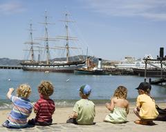 Children enjoying a sunny July afternoon at Hyde Street Pier with historic ships in the background