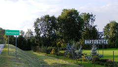 Entry sign to Bartoszyce town in Poland with surrounding greenery