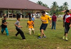 Lt. Cmdr. Paul Kim playing soccer with children at an orphanage during CARAT community service event