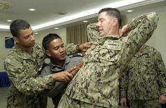 Chief Boatswain Mate Elias Inoa instructing Royal Malaysian Navy Sub-lieutenant Mukhrim on positive control of hostile subject during CARAT Malaysia 2013 joint training