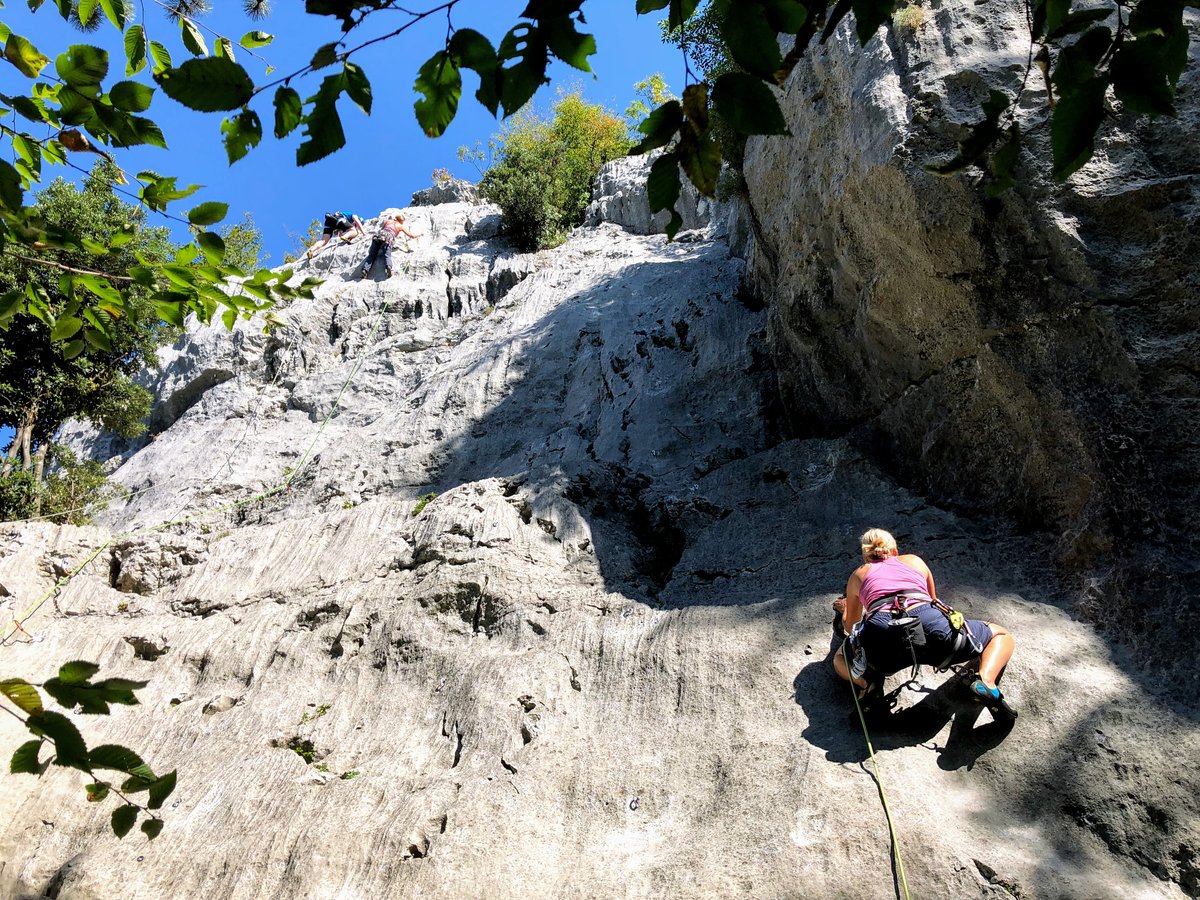 Muro Dell’Asino cliff face in Arco Italy covered with climbers and lush vegetation