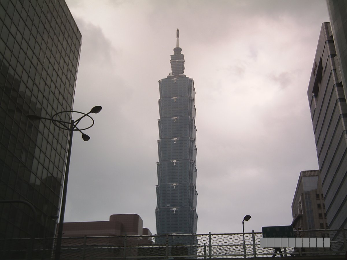 Tall Taipei 101 skyscraper against blue sky