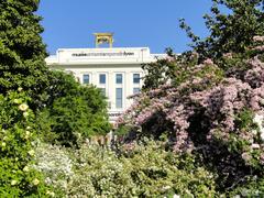 Panoramic view of Parc de la Tête d'Or in Lyon with green lawns and trees under a blue sky
