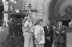 Herman van Veen holding the world torch walking towards Prince Claus during the First Earth Run at the Peace Palace in The Hague, 1986