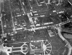 Aerial view of the Peace Palace in The Hague with surrounding houses and garden layouts on April 18, 1925, featuring a small airplane HNACK in the center flown by three aviators during their return flight from Paris