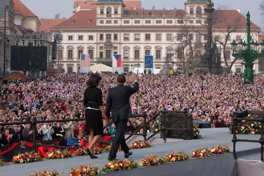 Barack Obama waving with Michelle Obama walking beside him in Prague's Hradcany Square on April 5, 2009