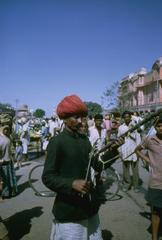 Bazaar merchants setting up wares in Jaipur street with Hawa Mahal in background