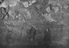 Old photograph of Smocza Jama cave entrance with historical stone work and trees