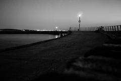 End of the road at Den Haag Scheveningen harbor with cloudy sky and industrial structures