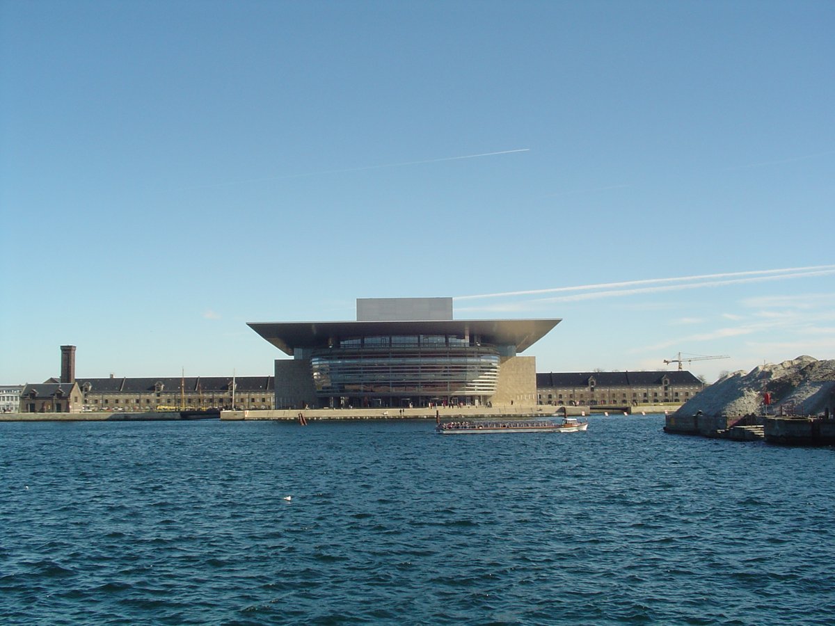 Copenhagen Opera House illuminated at night with reflections on water