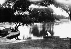 Zesfuerudo Park in Shanghai with lush green trees, gently sloping grassy areas, pavilion, pond, benches, and willow shadows by the clear pond