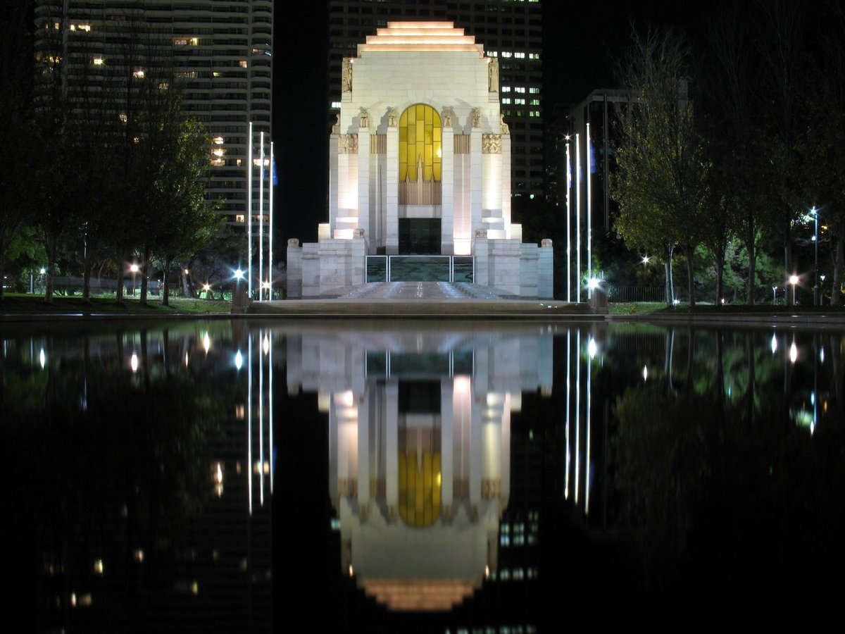 ANZAC War Memorial in Sydney Australia at night with illuminated facade and starry sky