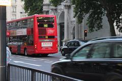 Red double-decker London bus on street with passengers in July 2011