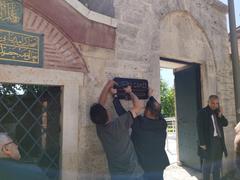 Workers mounting a new name plate reading 'Kariye Mosque' in front of the medieval Chora church in Istanbul